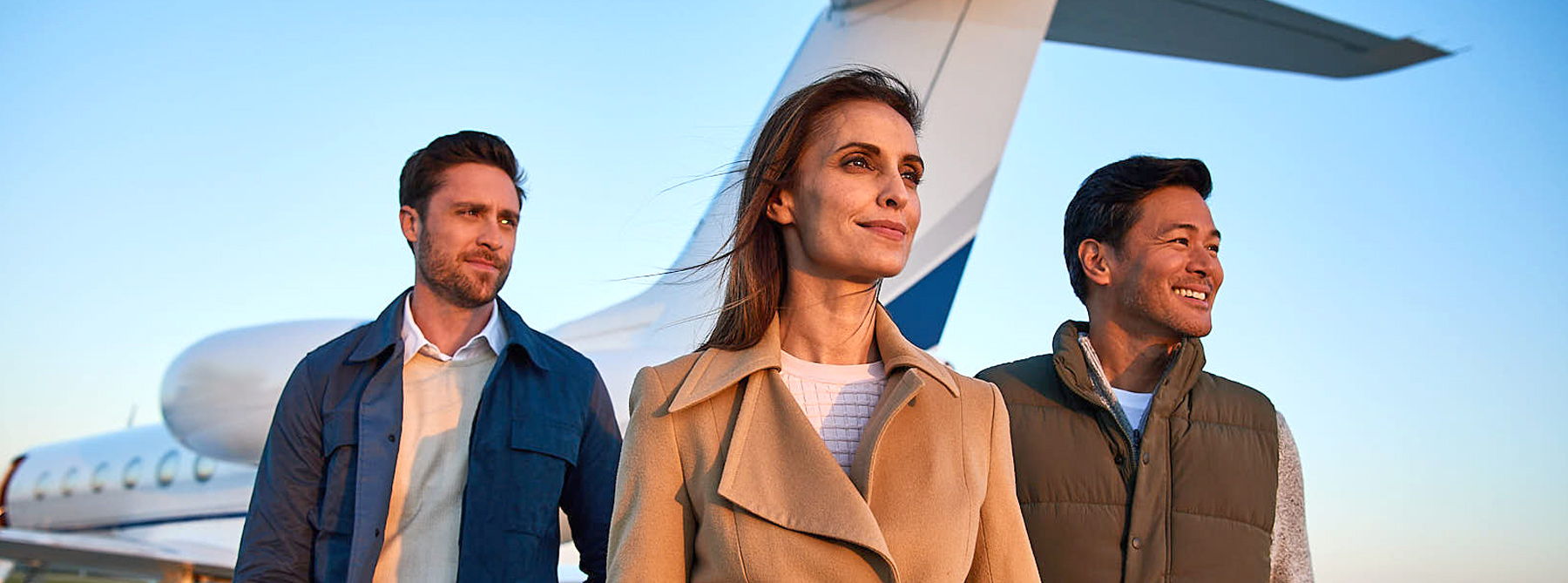 A women and 2 men standing in front of an air plane