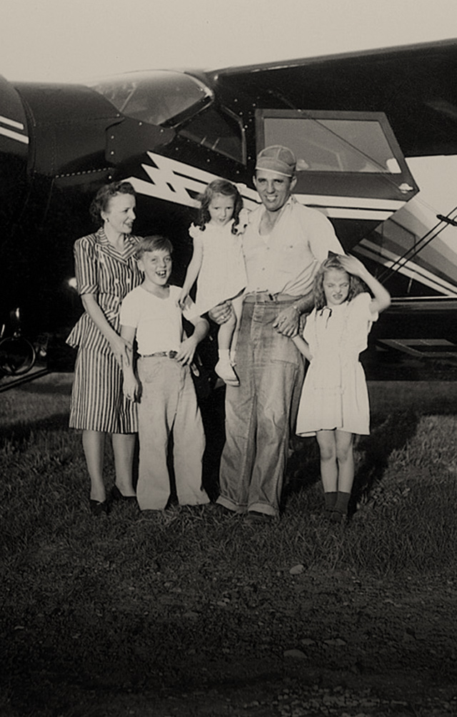 Historic picture of George J Priester and family in front of an airplane