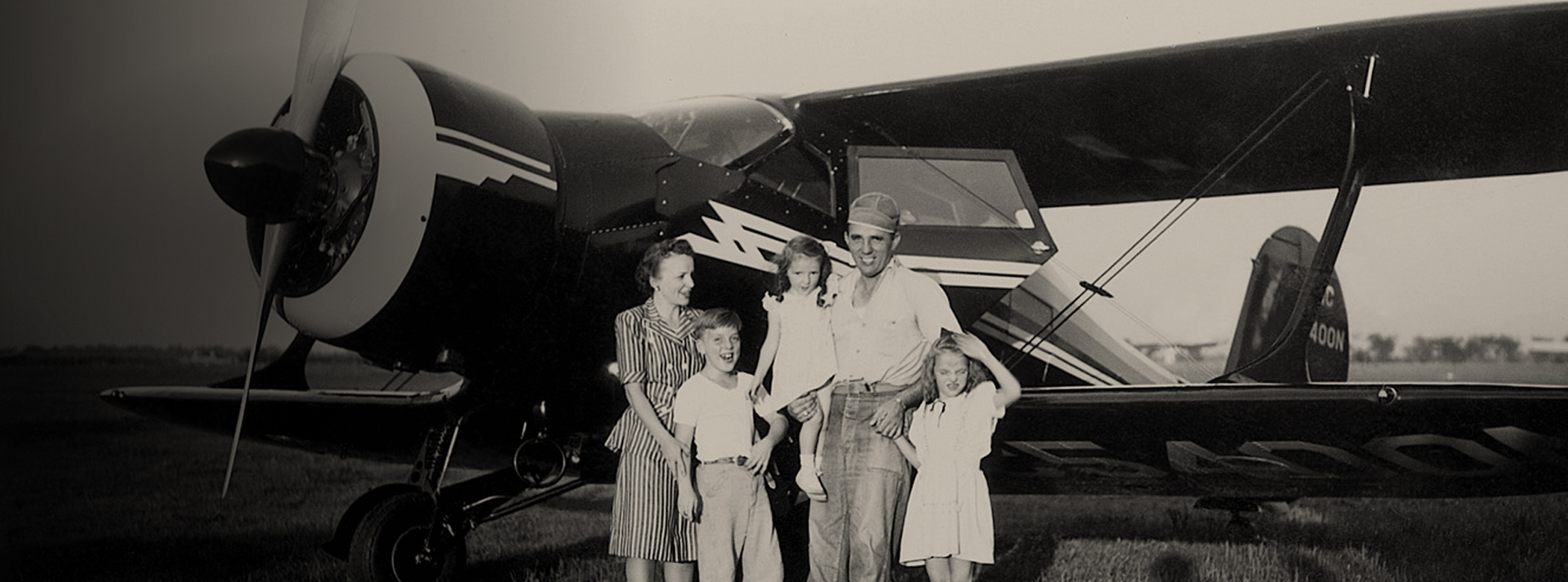 Historic picture of George J Priester and family in front of an airplane